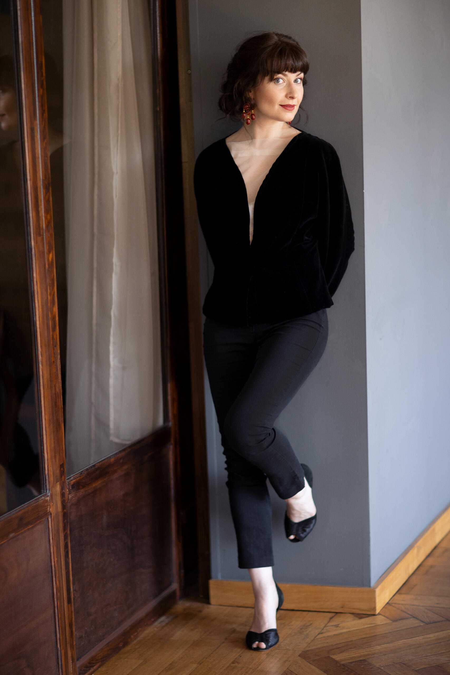 Marie Hänsel lehnt an einer grauen Wand und schaut in die Kamera